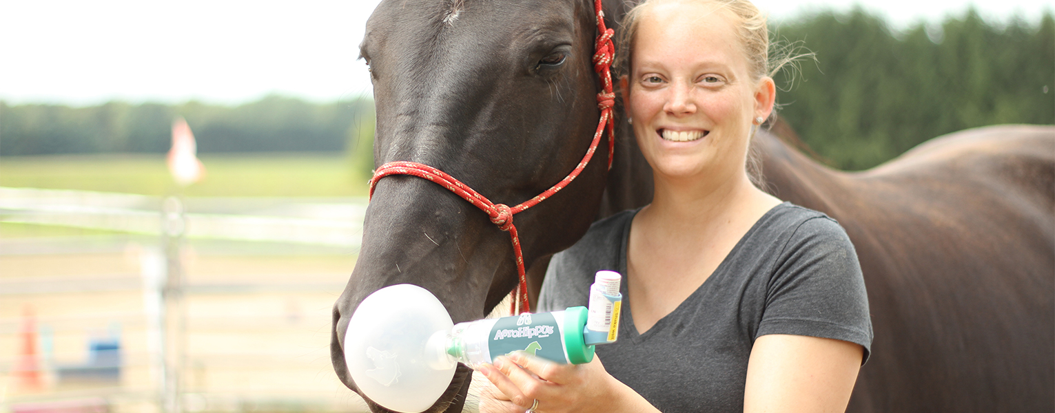 Woman delivering medication to horse